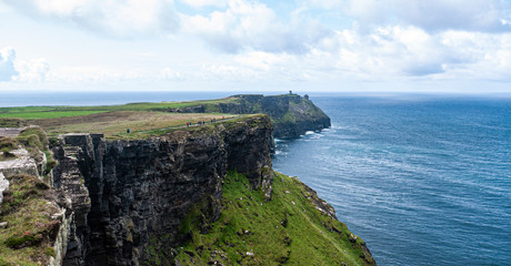 Beautiful view of the famous Cliffs of Moher in County Clare, Ireland. Showing the green grass, blue sky & blue waters of the Atlantic.