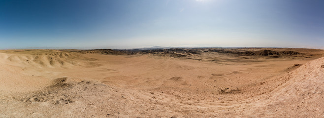 Fototapeta na wymiar Panoramaaufnahme der kargen und weiten Wüstenlandschaft am Welwitschia Drive mit Bergen und spärlicher Vegetation in der Wüste Namib bei Swakopmund in Namibia