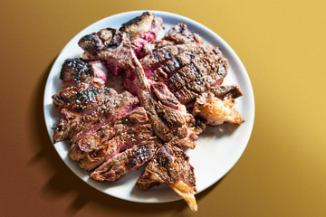 White round plate with cut grilled T-bone steak