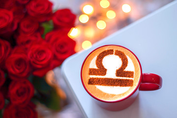 white cup of coffee with the symbol of the zodiac Libra
