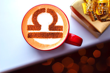 white cup of coffee with the symbol of the zodiac Libra