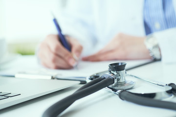 Mid section of female doctor writes prescription to patient at worktable. Panacea and life save, prescribing treatment.