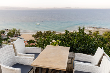 wicker chairs and tables in a summer cafe with sea views. Restaurant sea terrace