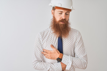 Young redhead irish architect man wearing security helmet over isolated white background with hand on stomach because nausea, painful disease feeling unwell. Ache concept.