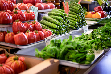 Appetising variety of vegetables on the counter, fresh tomatoes, cucumber, salad, peppers, carrots.