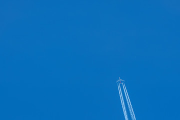 Passenger airplane. View exactly from below, silhouette against the blue sky.