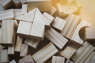 house from natural color wooden block on the stack of wooden blocks with orange light effect