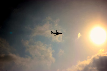 Flying plane against the sky at sunset