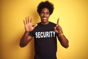 American safeguard man with afro hair wearing security uniform over isolated yellow background...