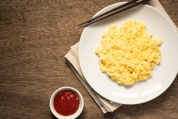Scramble on a white plate with spoon and chopsticks,ketchup bowl,copy space
