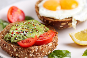 Avocado burger. Vegan toast brunch with egg. Healthy lunch sandwich with green spread. Fitness organic recipe. Light balanced diet dish. Health breakfast snack with basil, tomatoes and chili