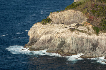 Splashing waves on rocky cliffs. Atlantic ocean at Sao Miguel island, Azores, Portugal