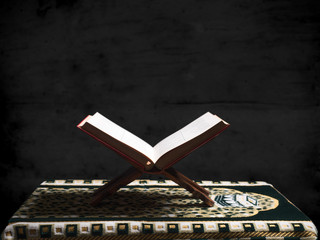 Quran or Kuran ( the islamic holy book) on black