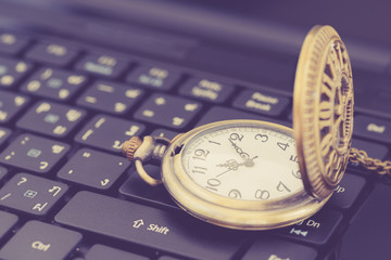 Deadline concept : Vintage gold pocket watch on a black laptop keyboard, depicts a specific date or time limited for a job / work or task to be done / completed or finished before specified period. 