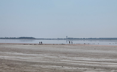 Beautiful landscape. Larnaca Salt Lake, general view. In the central part are small silhouettes of four people.