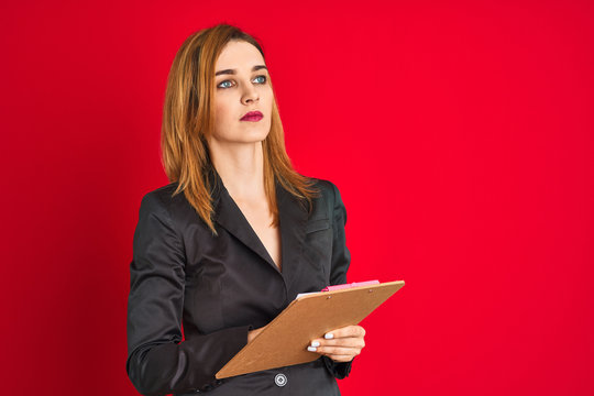 Young beautiful redhead businesswoman wearing suit holding flip board