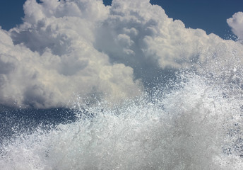Clouds on a background of blue sky and splashing waves