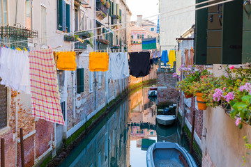 Fototapeta na wymiar Washing line with laundry clothing air drying over the channel on sunny day. Venice lifestyle