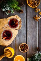 Mulled wine and fir branches frame on dark wooden background top view copy space