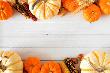 Autumn double border of pumpkins and fall decor on a rustic white wood background with copy space