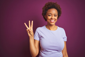 Young beautiful african american woman with afro hair over isolated purple background showing and...