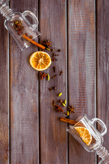 New Year beverage. Ingredients for mulled wine in glasses on dark wooden background top view copy...