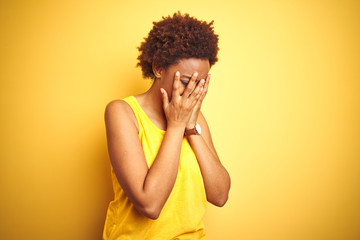 Beauitul african american woman wearing summer t-shirt over isolated yellow background with sad...