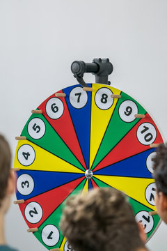 Young people gamble on the Wheel of Fortune and hope for the right lot. Concept: addiction or gambling