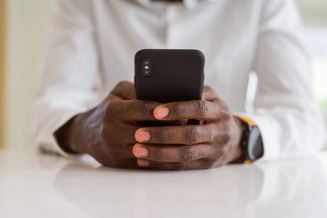 Close up of african man hands using smarpthone