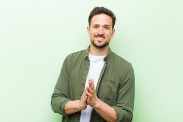 young handsome man feeling happy and successful, smiling and clapping hands, saying congratulations...