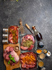 Cooking ingredients: marinated juicy meat, sauce, herbs, spices in jars, fresh basil