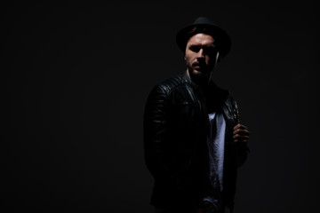 dramatic cool guy wearing leather jacket and hat