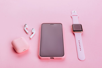 Up to date technology.Top view of diverse personal accessory laying on the pink background