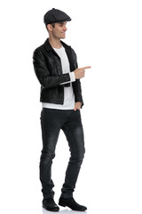 casual man standing with one hand in pocket pointing forward