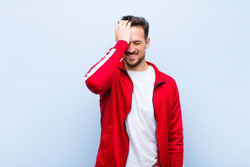 young handsome sports man or monitor laughing and slapping forehead like saying d‚Äôoh! I...