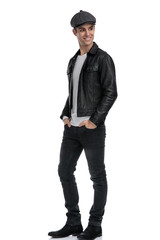 casual man standing with hands in pocket looking sideways joyfull