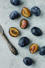 harvest of ripe blue plums on a table on a light background
