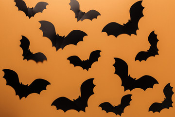 Halloween black paper bats on orange background. Top view Copy space - Image