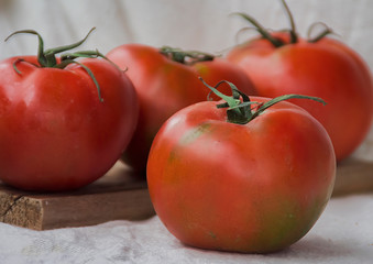 Tomates frescos  y maduros encima de una tabla de madera