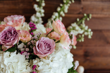 Spring bouquet of mixed flowers on vintage wooden wall background behind