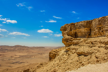 Fototapeta na wymiar desert scenic background wallpaper view of high rock cliff above valley on vivid blue sky background, copy space