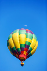 colorful hot air balloon with moon in blue sky