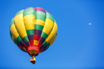 colorful hot air balloon with moon in blue sky