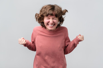 Excited caucasian woman with arms raised jumping hearing positive news.