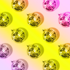 New year baubles. Shiny gold disco balls on neon background. Pop disco style attributes, retro concept. Creative Christmas pattern. Flat lay, top view.