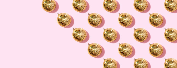 New year baubles. Shiny gold disco balls on pink background. Pop disco style attributes, retro concept. Creative Christmas pattern. Flat lay, top view.