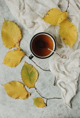 cup of tea with autumn leaves on wooden background