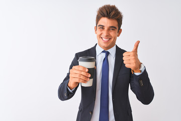 Young handsome businessman wearing suit holding coffee over isolated white background happy with big smile doing ok sign, thumb up with fingers, excellent sign