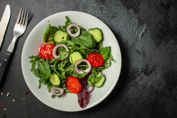 Healthy salad, leaves mix salad (mix micro greens, cucumber, tomato, onion, other ingredients). food background. copy space