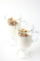 Crispy muesli in a glass with fresh yogurt, morning Breakfast, light snacks. Breakfast cereals isolated on white background, selective focus.